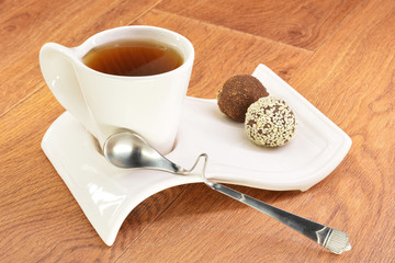 Black tea in a white mug and cake