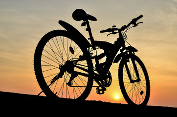Fototapeta premium Silhouette of mountain bike with sunset sky 