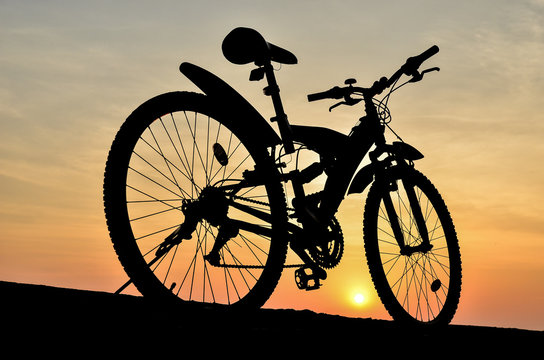 Silhouette of mountain bike with sunset sky 