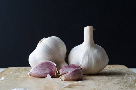 Garlic Bulbs and Cloves on Chopping Board
