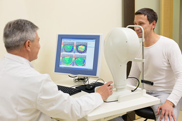 Man having his eyes examined by an eye elderly doctor.