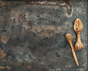 Wooden kitchen utensils on rusted metal plate background