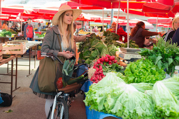 Attractive blonde woman with straw hat and bike on Marketplace.