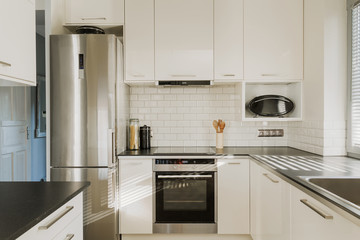 Chrome fridge in white kitchen