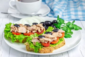 Tuna fish sandwiches on the white plate and coffee