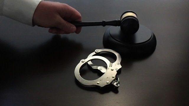 Slow Motion Judge Slamming Gavel with Handcuffs on Wood Table