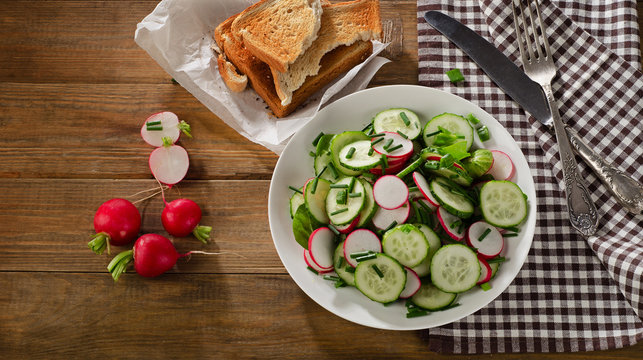 Fresh salad with radish and cucumbers .