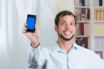 young happy man holding his cell phone and showing the screen