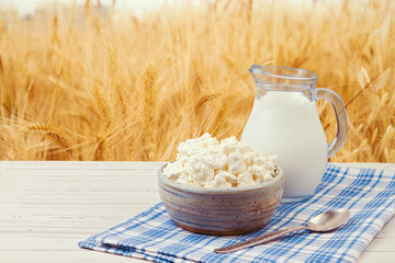 Milk and cottage cheese over wheat field
