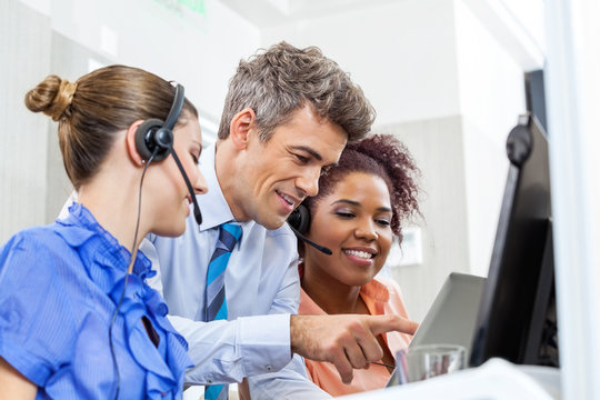 Manager With Customer Service Executives Using Tablet Computer