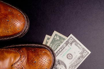 Dollars under a pair of Shoes