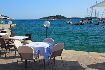 Tables of cafe on the embankment of the city of Hvar.