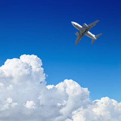 Airplane flying in the blue sky with clouds
