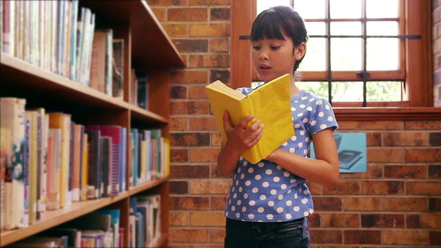 Pupil taking book from shelf at the library