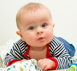 Toddler boy laying on a blanket