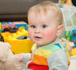 Funny infant in bright bode sitting on a floor with toys - 81595108