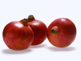Several whole pomegranate on a white background