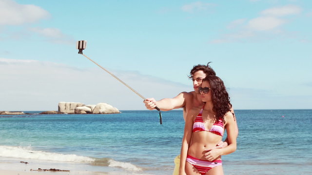 Happy couple doing selfie with monopod