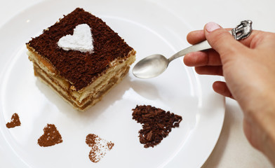 Girl eating tiramisu cake with heart