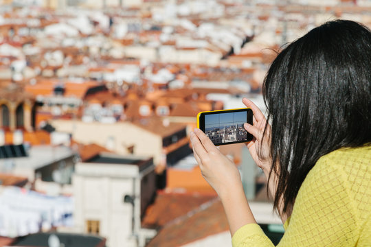 Young Woman Taking Mobile Pictures from a City Viewpoint