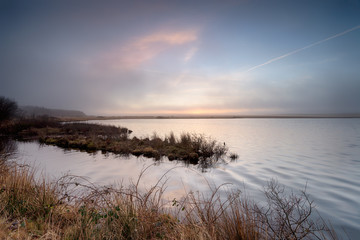 Foggy sunrise over Crowdy reservoir on Bodmin Moor in Cornwall