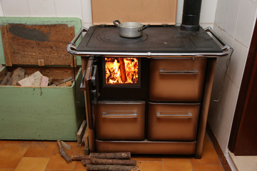 antique stove a wood-burning Stove with fire lit in the old moun