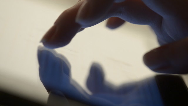 macro closeup finger touching tablet computer touchscreen