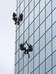 sanitation workers cleaning glass facade hotel