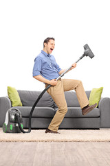 Guy playing guitar on a vacuum cleaner wand