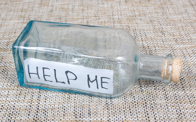 Bottle with sign HELP ME on a pockmarked background - 81604171