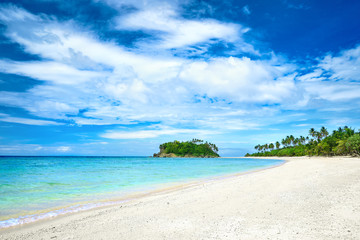 Beautiful tropical beach on the background of palm trees island