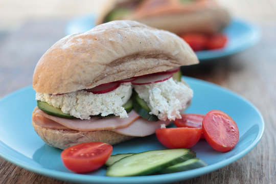 Freshly prepared sandwich with ham, veggies and cottage cheese.