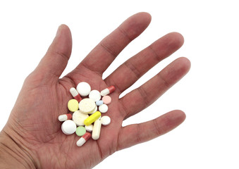 Various pills in hand on white background.