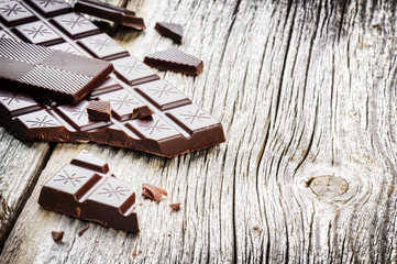 Dark chocolate tablets on old wood background
