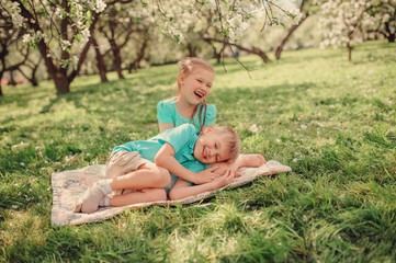 Naklejka na ściany i meble happy brother and sister having fun in spring apple garden