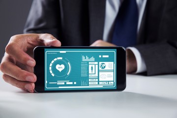 Composite image of businessman using smartphone