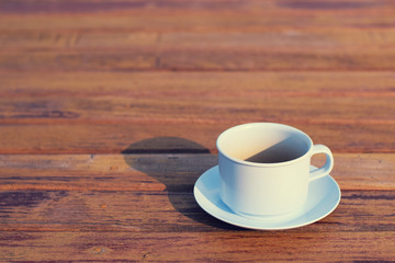 Coffee cup on wooden table (vintage background)