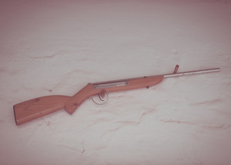 vintage old western wooden rifle hanged on white wall