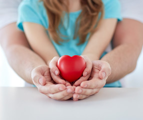 close up of man and girl holding red heart shape