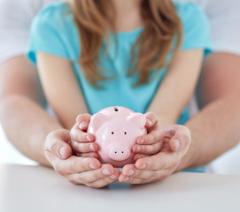Obraz na płótnie Canvas close up of family hands with piggy bank