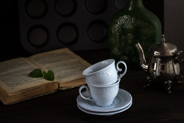 Still life with cups and book in vintage style