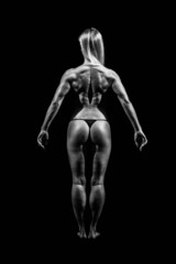 Fototapeta na wymiar Athletic young woman showing muscles of the back and hands