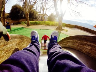 bambino gioca al parco sullo scivolo, punto di vista particolare