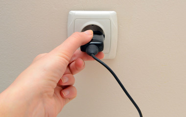 Women hand connect electricity plug