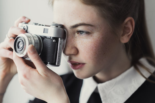 Fototapeta face of a beautiful woman photographer and old camera