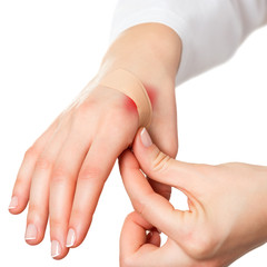 Putting plaster on hurt red skin