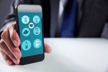 Composite image of businessman using smartphone