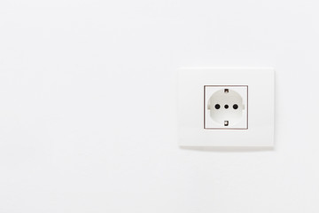 Empty white electric socket on a white wall