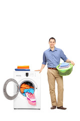 Young man standing by a washing machine