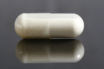 close up of white gelatin capsule on black background
